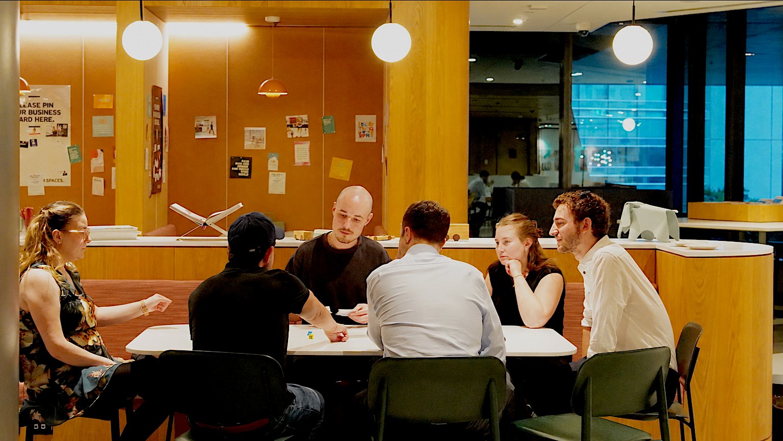 A group of people working through a workshop around a table.